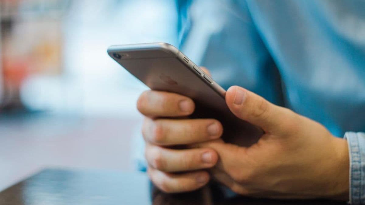 Elinde akıllı telefon tutan ve ekranı kaydıran biri