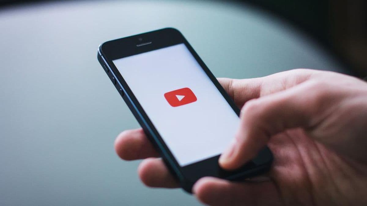 Elinde YouTube açık akıllı telefon tutan bir el
