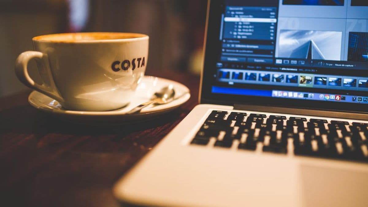 Dizüstü bilgisayarda açık video düzenleme programı ve yanında kahve